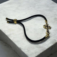 Load image into Gallery viewer, Gold Cross Adjustable Bracelet with Black Cord
